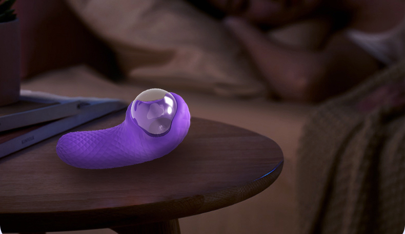 A purple female vibrator is placed on the bedside of a bedroom